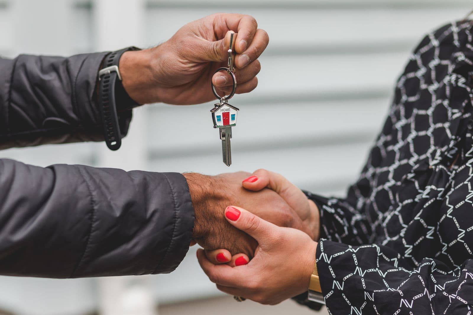 Handshake sealing a property deal with house keys on the table